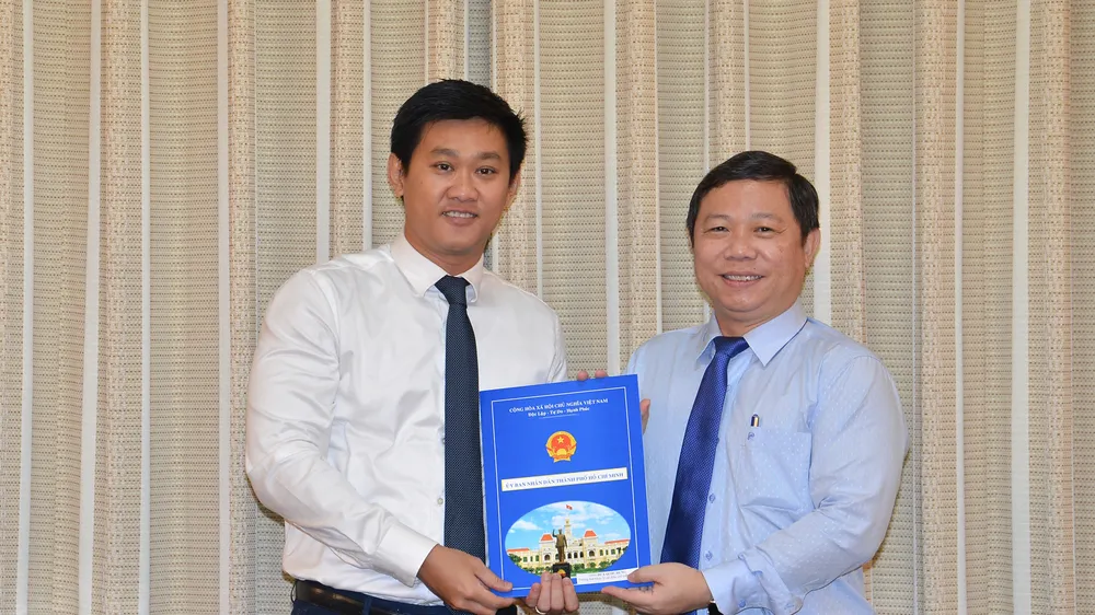 Phó Chủ tịch UBND TPHCM Dương Anh Đức trao quyết định cho đồng chí Hứa Quốc Hưng.Ảnh: VIỆT DŨNG