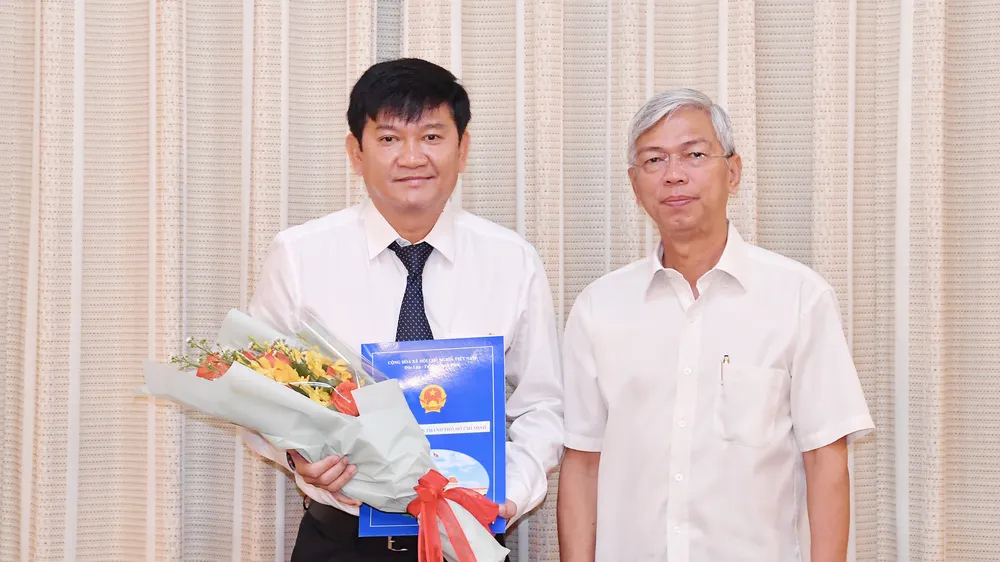 Phó Chủ tịch UBND TPHCM Võ Văn Hoan trao quyết định cho ông Trần Quang Minh. Ảnh: VIỆT DŨNG