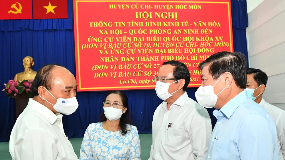 Chủ tịch nước Nguyễn Xuân Phúc trao đổi cùng các đồng chí lãnh đạo TPHCM tại hội nghị. Ảnh: VIỆT DŨNG