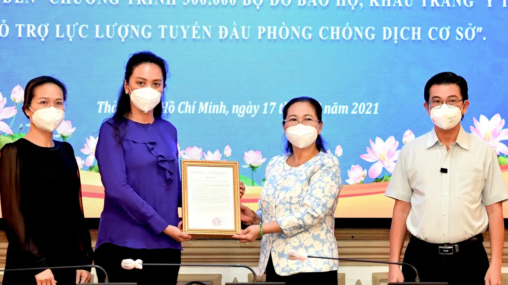 Chủ tịch HĐND TPHCM Nguyễn Thị Lệ tiếp nhận và trao thư cám ơn Công ty Bảo trợ Tập đoàn Vạn Thịnh Phát. Ảnh: VIỆT DŨNG 