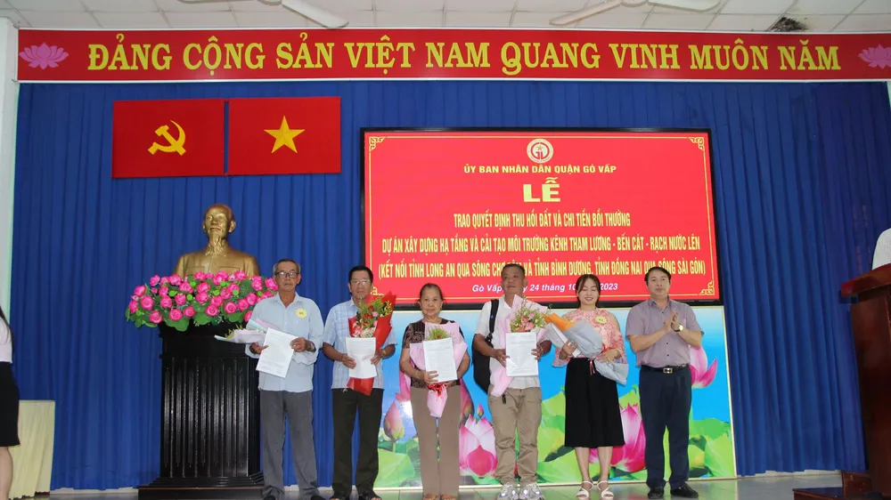 Chủ tịch UBND quận Gò Vấp Nguyễn Trí Dũng trao quyết định và hoa cho các hộ dân