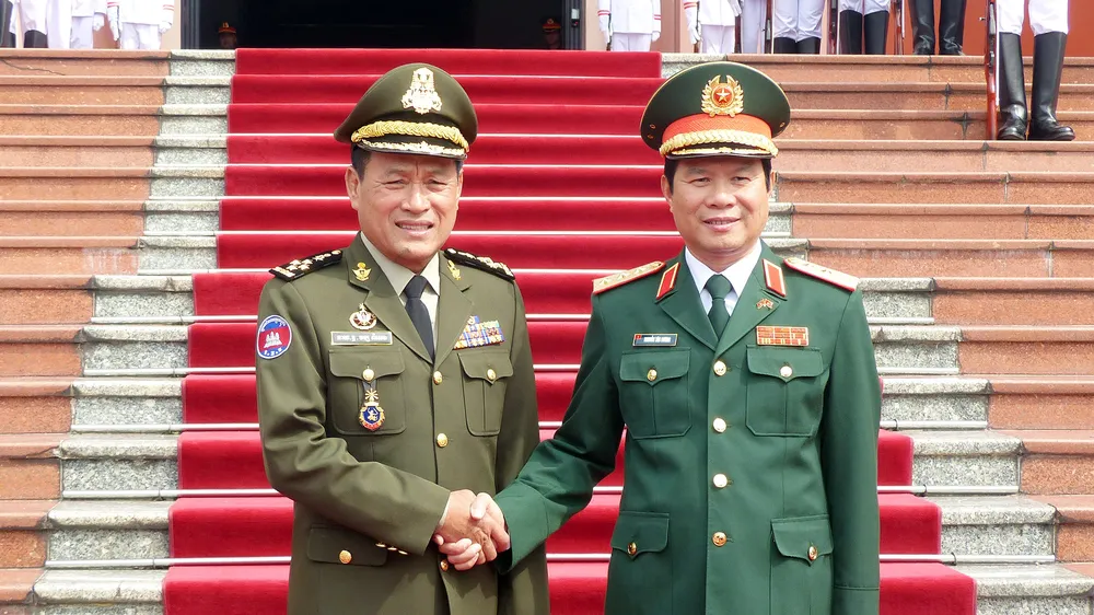 Thượng tướng Nguyễn Tân Cương tặng hoa Đại tướng Vong Pisen tại lễ đón chính thức. Ảnh T.B 