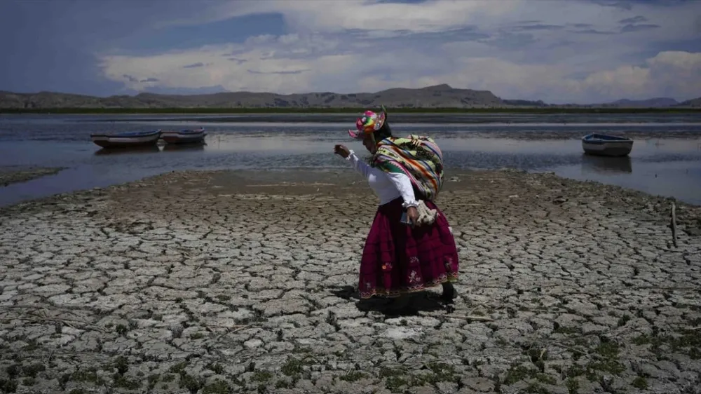 Một người dân Peru di chuyển qua lòng sông khô cạn vì hạn hán. Ảnh: REUTERS