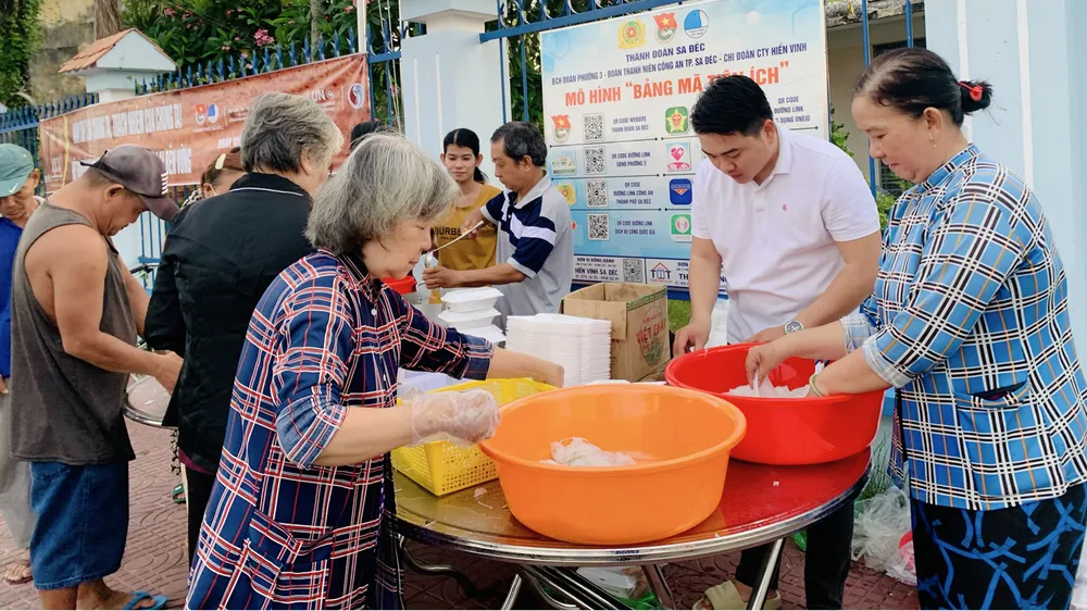 Anh Ngô Văn Quí (thứ 2 từ phải sang) chuẩn bị những suất ăn 0 đồng trao đến người nghèo