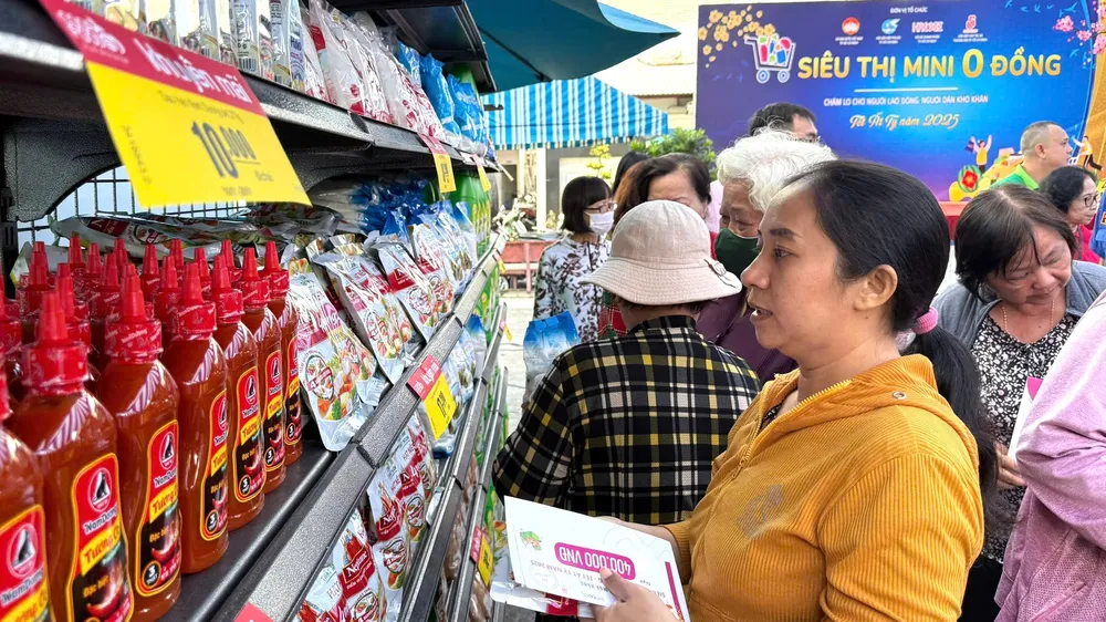 Chị em phụ nữ khó khăn chọn mua hàng tết tại "Siêu thị mini 0 đồng" sáng 17-1