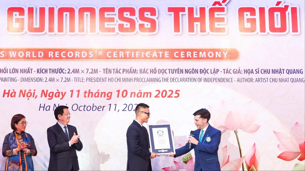 Đại diện Tổ chức Kỷ lục Guinness thế giới trao bằng chứng nhận cho họa sĩ Chu Nhật Quang