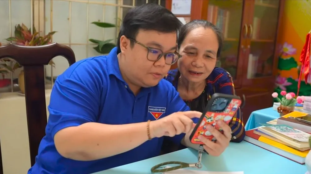 Đoàn viên thanh niên phường Vũng Tàu (TPHCM) hướng dẫn người dân sử dụng điện thoại thông minh để nộp hồ sơ hành chính trực tuyến 