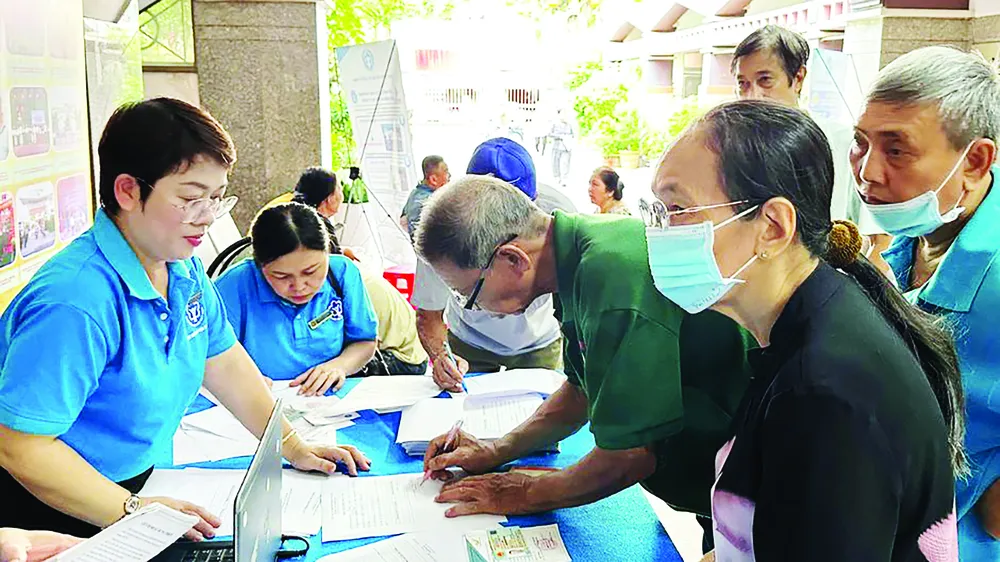 Chuyên viên BHXH TPHCM tư vấn chính sách BHYT, BHXH cho người dân (ẢNH: ĐÔNG SƠN)
