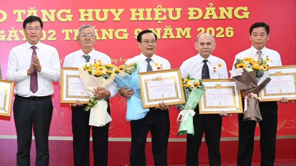 Phó Bí thư Thường trực Thành ủy TPHCM Lê Quốc Phong trao Huy hiệu Đảng đến các đảng viên cao niên. Ảnh VIỆT DŨNG