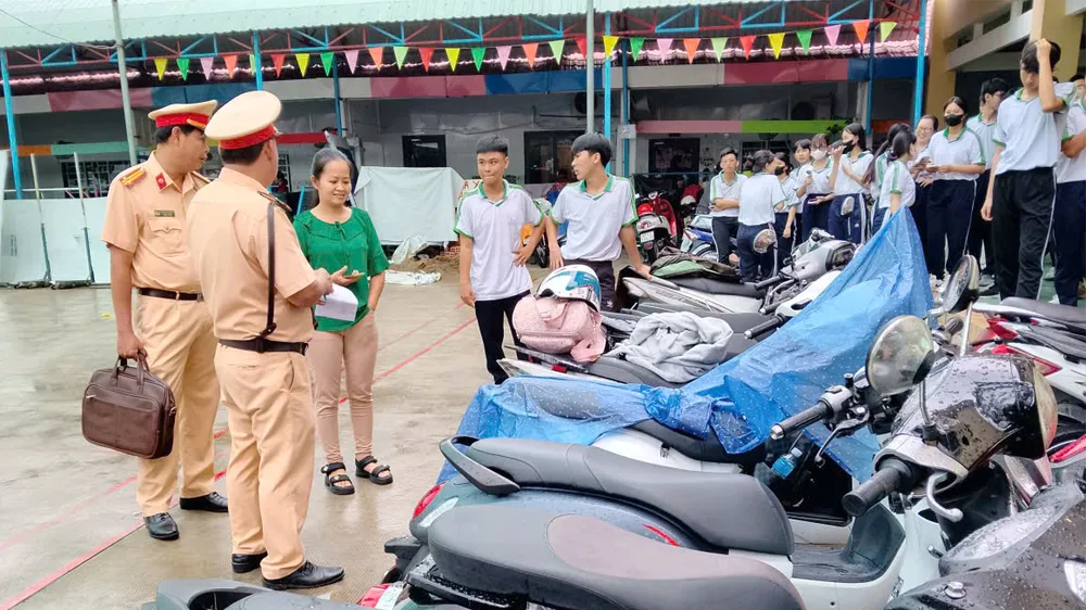Lực lượng Cảnh sát giao thông Công an tỉnh An Giang kiểm tra bãi giữ xe một trường học trên địa bàn. Ảnh: NAM KHÔI