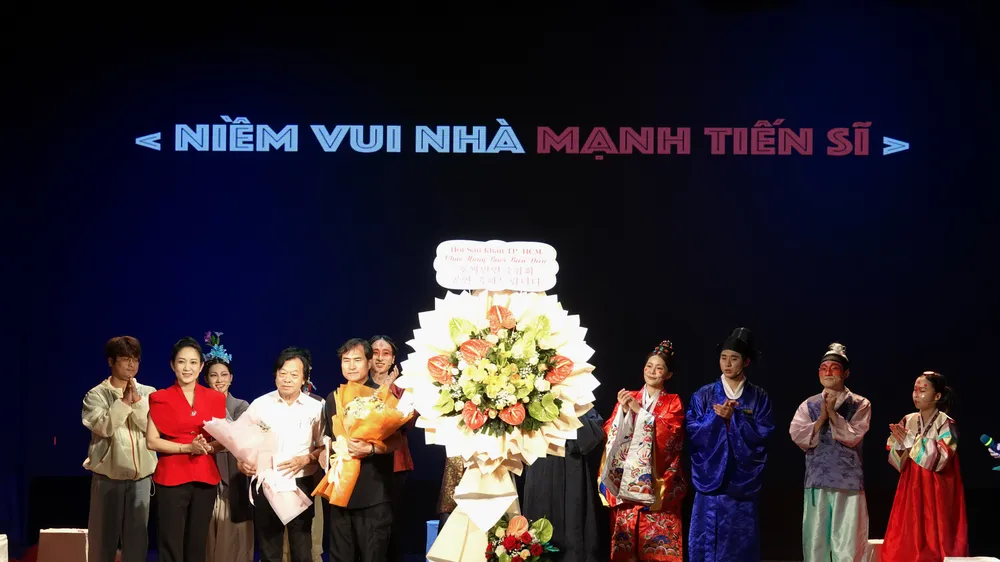 Phó Giám đốc Sở VHTT TPHCM tặng hoa chúc mừng hai đơn vị là Hội Sân khấu TPHCM và Đoàn nghệ sĩ Sân khấu TP Busan, Hàn Quốc đã phối hợp tổ chức biểu diễn thành công vở kịch "Niềm vui nhà Mạnh tiến sĩ". Ảnh: THÚY BÌNH