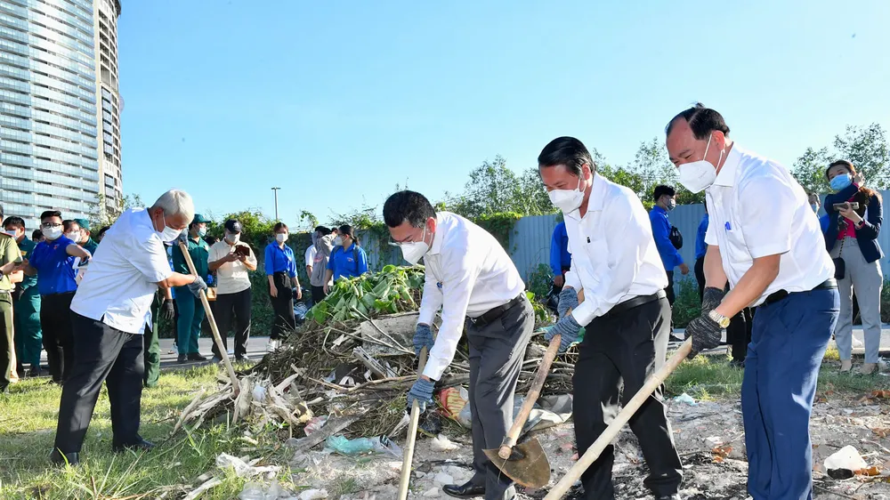 Các đồng chí lãnh đạo quận 7 tham gia dọn vệ sinh môi trường. Ảnh: VIỆT DŨNG