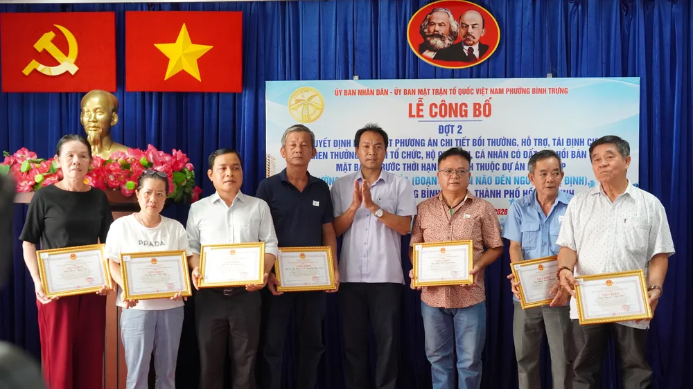 Chủ tịch UBND phường Bình Trưng Nguyễn Chí Thanh trao quyết định đến các hộ dân. Ảnh: BẢO HÂN