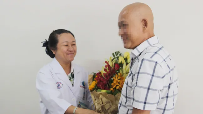Bác sĩ chúc mừng bệnh nhân Q. (bìa phải) đã bình phục hoàn toàn
