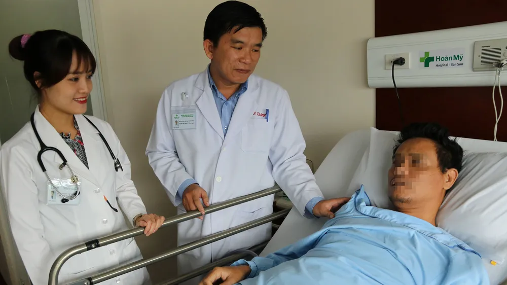 ​ Bác sĩ Cao Minh Thông thăm khám bệnh nhân sau phẫu thuật.