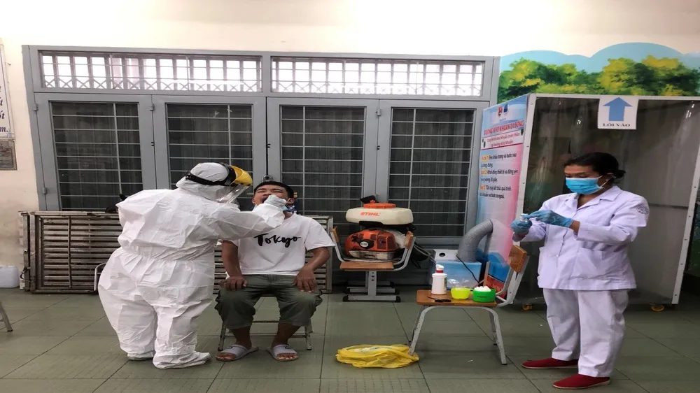 Các bác sĩ Trung tâm Y tế quận 10 đang lấy mẫu phết mũi họng cho bệnh nhân