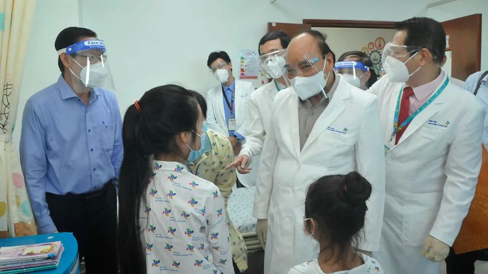 Chủ tịch nước Nguyễn Xuân Phúc thăm hỏi, tặng quà bệnh nhi tại Bệnh viện Nhi đồng Thành phố. Ảnh: CAO THĂNG