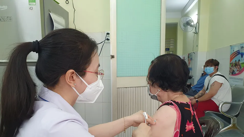 Nhân viên Trung tâm y tế quận 4 tiêm vaccine xuyên lễ cho người dân