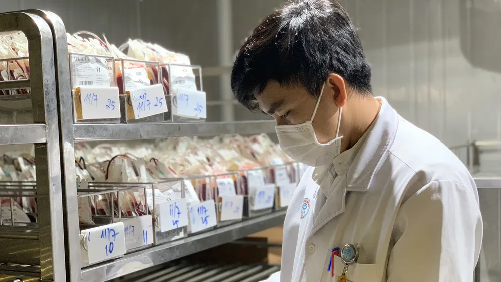 Kỹ thuật viên kiểm tra túi máu trước khi chuyển cho các tỉnh miền Tây