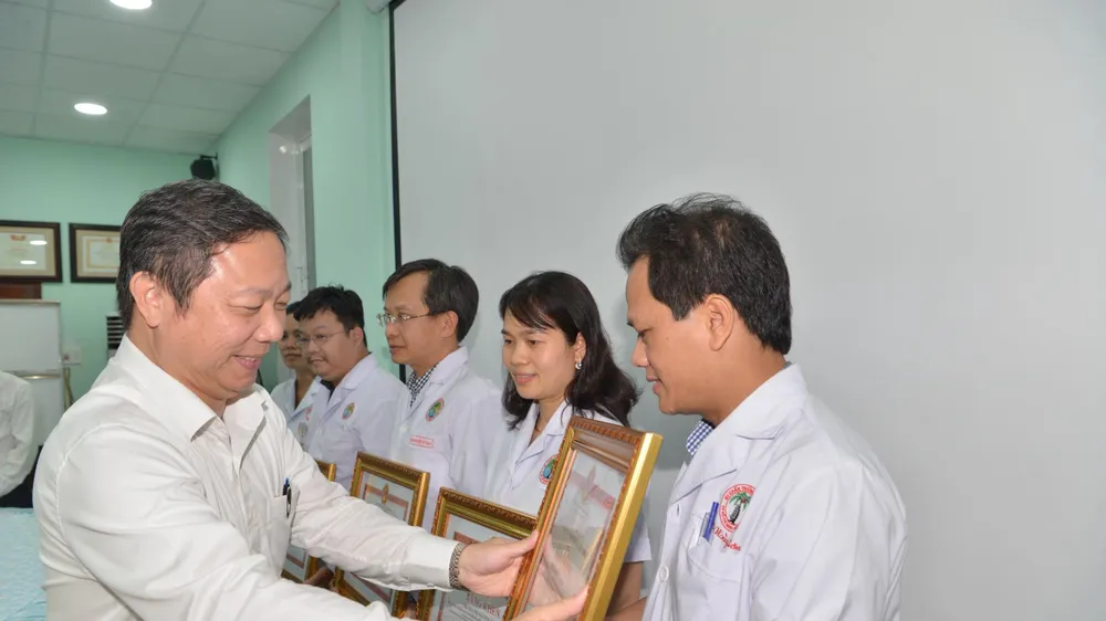 Phó Chủ tịch UBND TPHCM Dương Anh Đức trao tặng bằng khen cho các cá nhân. Ảnh: CAO THĂNG