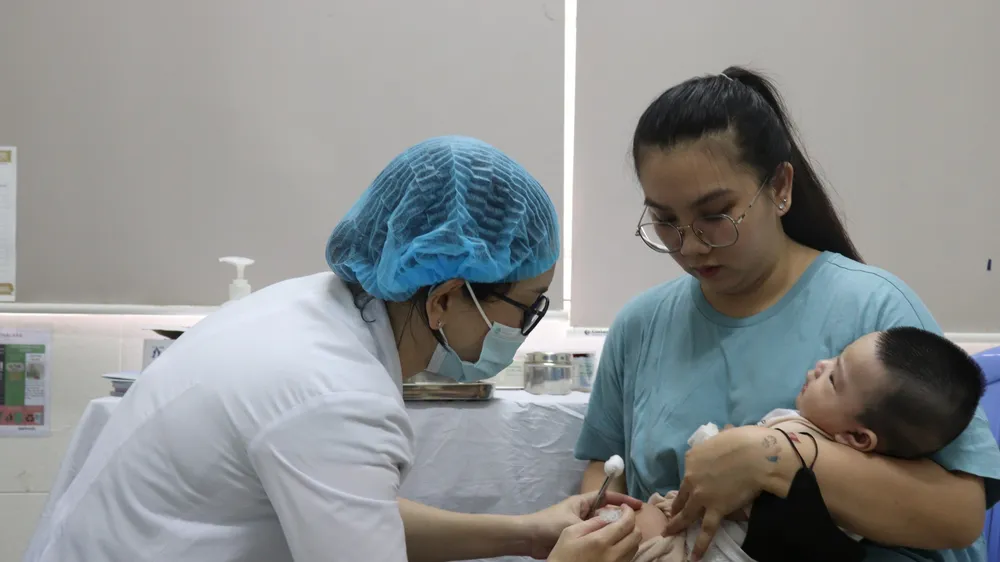 Nhân viên Trạm Y tế phường Phú Mỹ (quận 7) đang tiêm vaccine cho trẻ