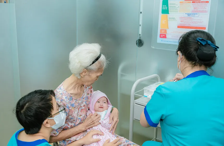 Nhân viên y tế một trung tâm tiêm chủng tiêm vaccine cho trẻ