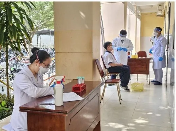 Nhân viên y tế lấy mẫu xét nghiệm cho các học sinh tiếp xúc gần ca bệnh não mô cầu tại Trường THCS Hai Bà Trưng (xã Hiệp Phước)