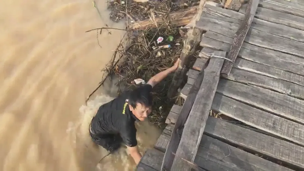 Mưa lớn, hàng chục người dân chèn chống để giữ cầu ván sông Trà Bồng