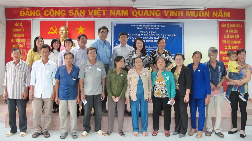  Người dân có hoàn cảnh khó khăn ở huyện Bình Chánh, TPHCM được tặng thẻ BHYT. Ảnh: VIỆT NGA