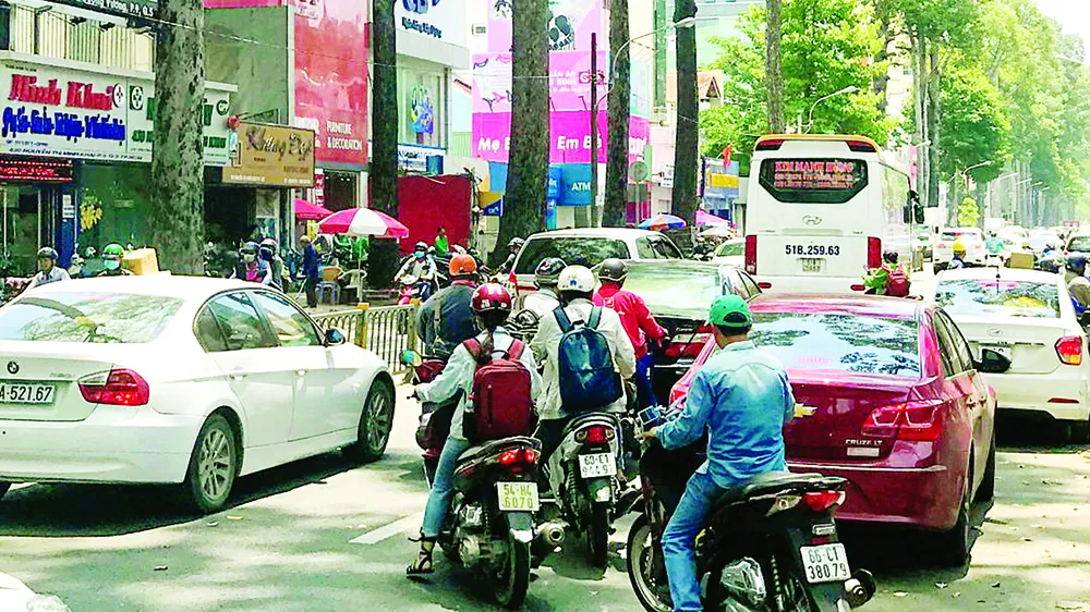  Cổng Bệnh viện Từ Dũ bị lấn chiếm nên các ô tô phải đón khách dưới lòng đường, gây khó khăn cho người tham gia giao thông