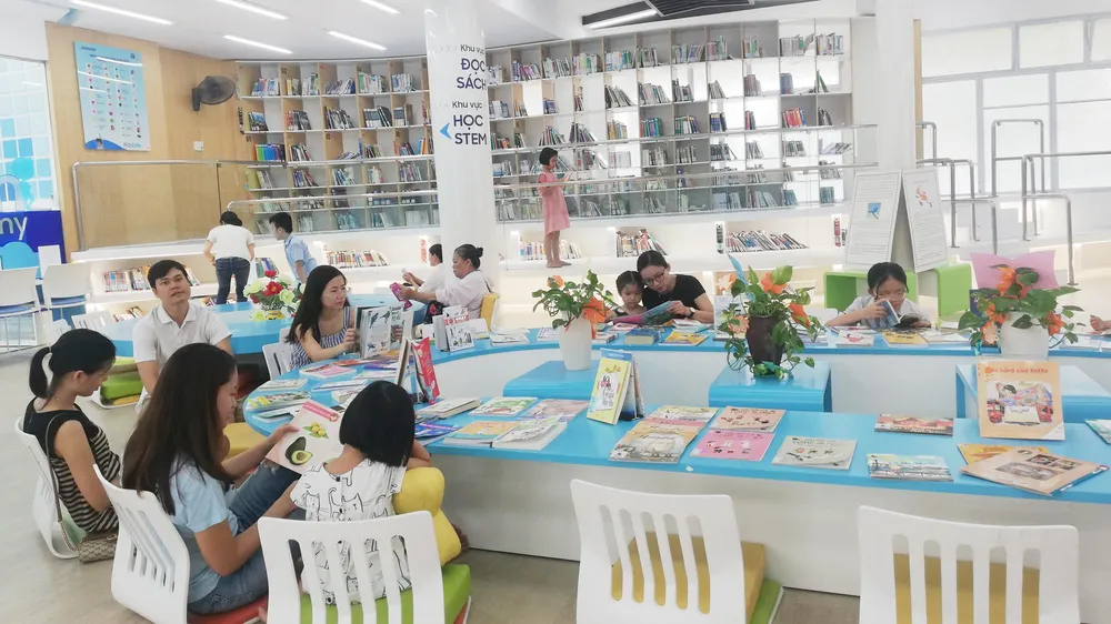 Phụ huynh và học sinh đọc sách tại ngày hội. Ảnh: PHẠM HUY
