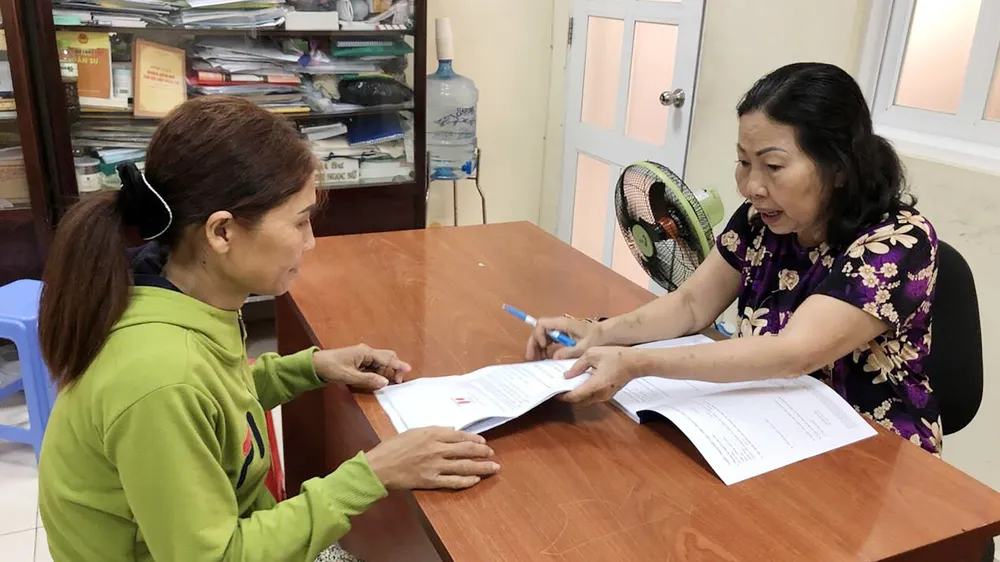 Luật sư Trần Ngọc Nữ (bên phải) hướng dẫn một phụ nữ bảo vệ quyền lợi của mình. Ảnh: HOÀNG LONG