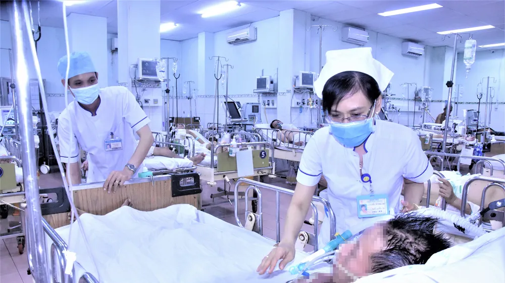 Điều dưỡng Trần Thị Thu An chăm sóc cho bệnh nhân V. tại Khoa Hồi sức cấp cứu - Chống độc, BV Phạm Ngọc Thạch. Ảnh: QUANG HUY