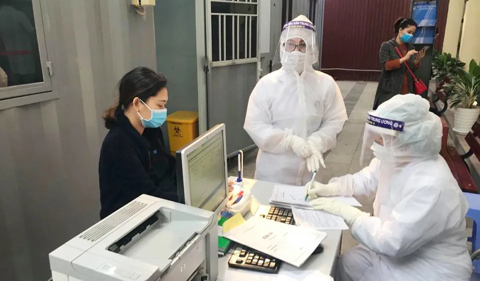  Nhân viên y tế làm thủ tục thăm khám cho người bệnh tại khu vực phòng khám "dã chiến" của Bệnh viện Phụ sản Trung ương. Ảnh: ncov.moh.gov.vn