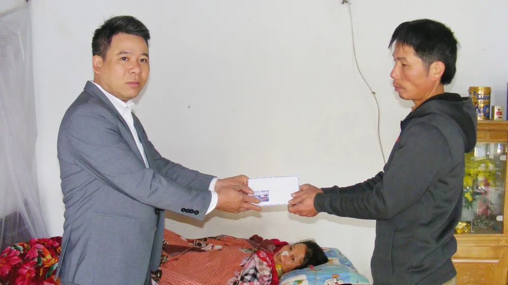 Thay mặt Báo SGGP, ông Nguyễn Bá Long, Bí thư Đảng ủy xã Đông Quang (Đông Sơn, Thanh Hóa) trao tiền của bạn đọc báo cho anh Lê Duy Thủy