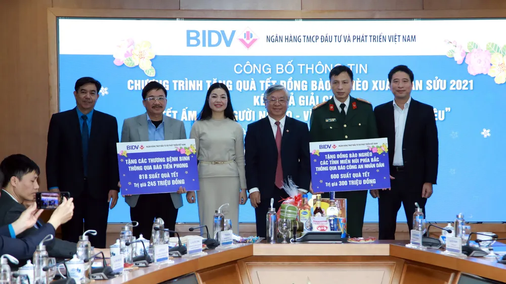 Đại diện BIDV trao bảng tượng trưng cho các đơn vị để tặng quà Tết cho người nghèo 