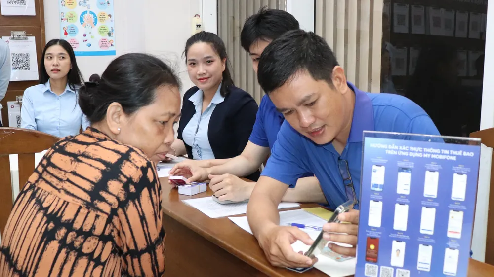 Cán bộ Trung tâm Phục vụ hành chính công phường Xóm Chiếu hỗ trợ người dân thực hiện thủ tục hành chính. Ảnh: THÁI PHƯƠNG