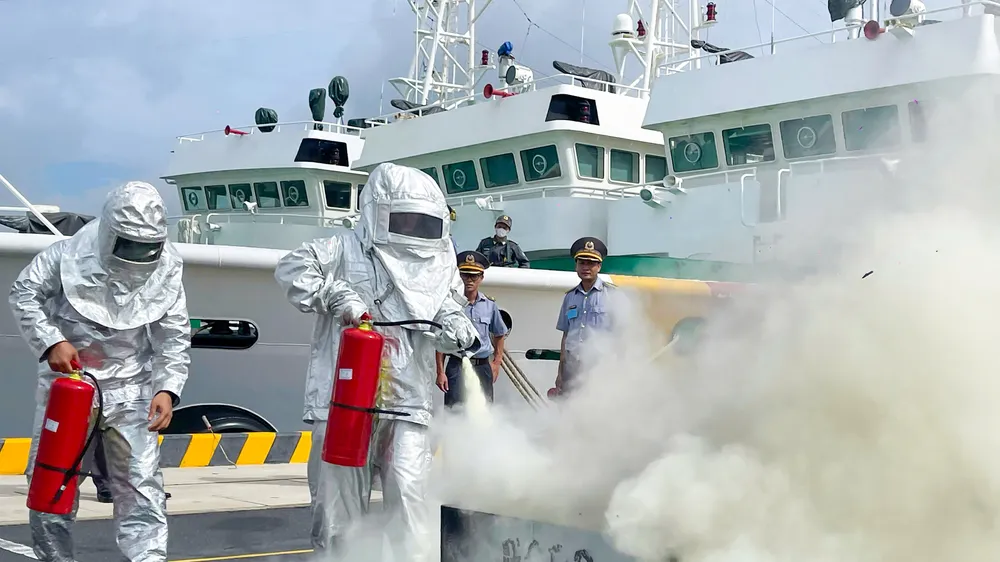 Cán bộ, nhân viên Chi đội Kiểm ngư số 2 tham gia chữa cháy bằng bình cứu hỏa. Ảnh: MẠNH THẮNG