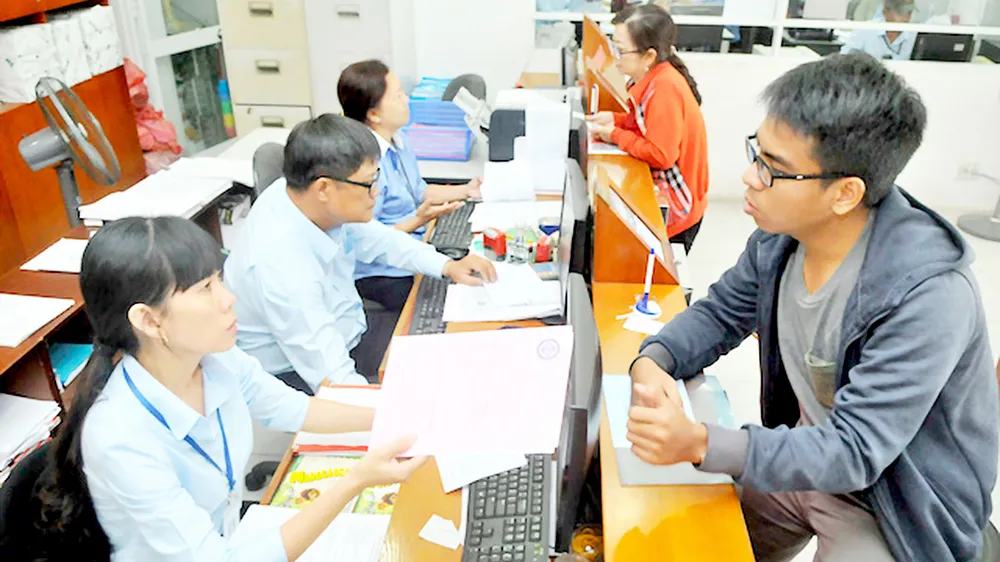 Tư vấn người dân gắn đồng hồ nước mới tại Công ty cổ phần Cấp nước Gia Định. Ảnh: CAO THĂNG