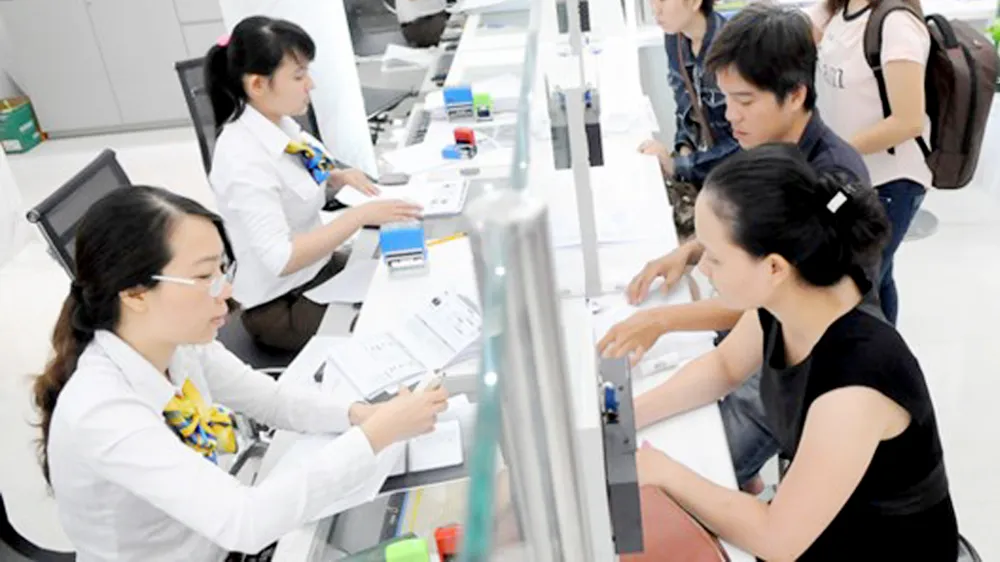 Xây dựng đội ngũ công chức chuyên nghiệp góp phần giảm sự trì tuệ của bộ máy. Ảnh giải quyết hồ sơ cho người dân tại UBND quận 1