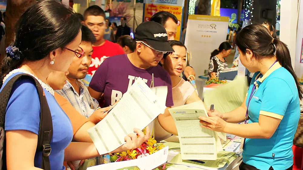 Khách hàng tìm hiểu các tour du lịch tại một hội chợ khuyến mãi ở TPHCM 