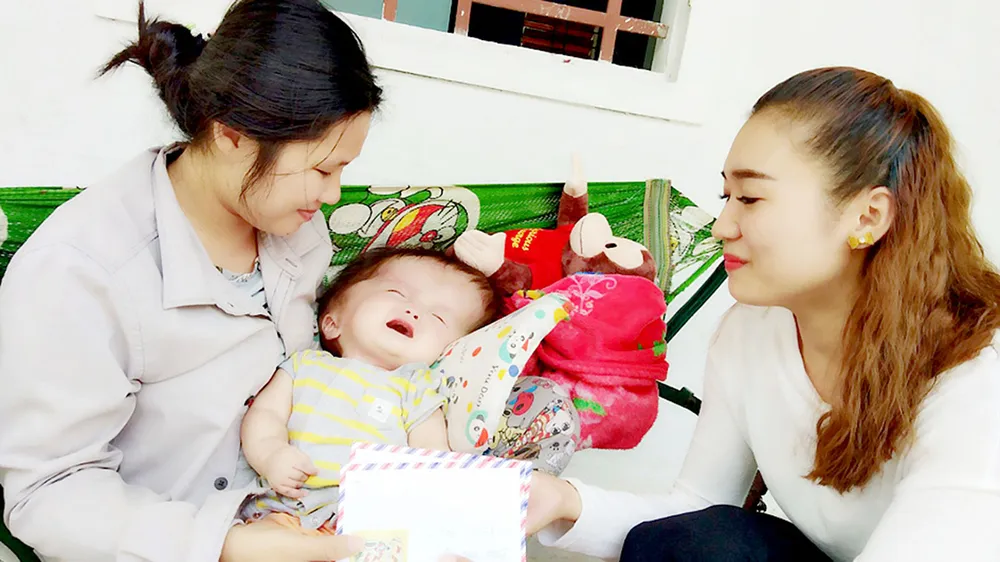 Đại diện Báo SGGP trao chị Hiệp số tiền 41 triệu đồng bạn đọc giúp cháu Phước điều trị bệnh