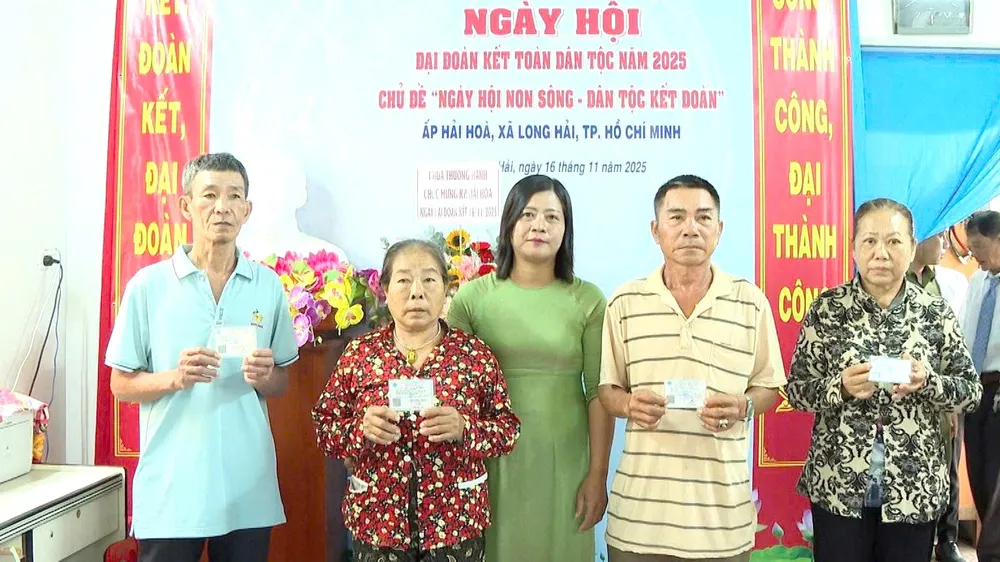 Bà Nguyễn Thị Ngọc Liên, Phó Chủ tịch Ủy ban MTTQ Việt Nam xã, Chủ tịch Hội LHPN xã Long Hải trao thẻ BHYT cho hộ khó khăn tại Ngày hội Đại đoàn kết toàn dân tộc năm 2025 ở ấp Hải Hòa