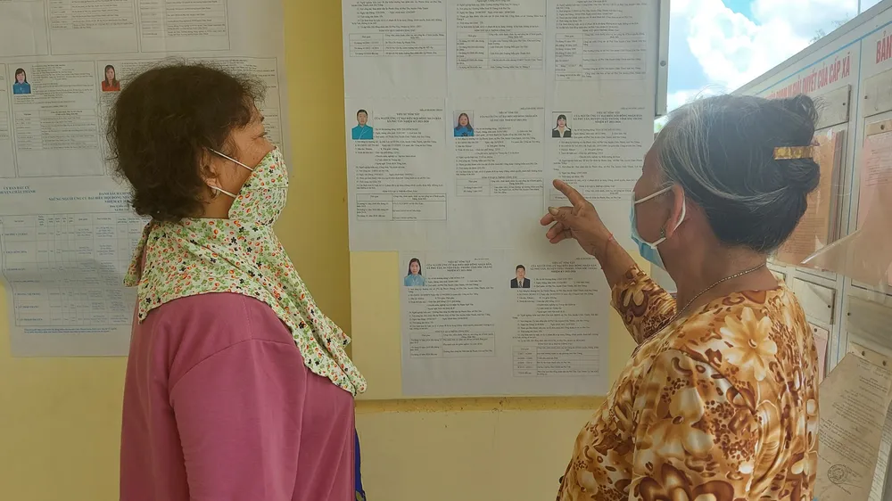 Cử tri là đồng bào dân tộc Khmer tại Sóc Trăng tìm hiểu thông tin những người ứng cử. Ảnh: TUẤN QUANG