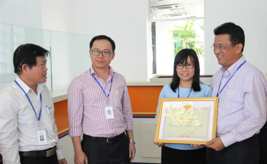 Ông Ngô Tấn Cư, Giám đốc Điện lực Đà Nẵng tặng giấy khen cho chị Trần Thị Anh 