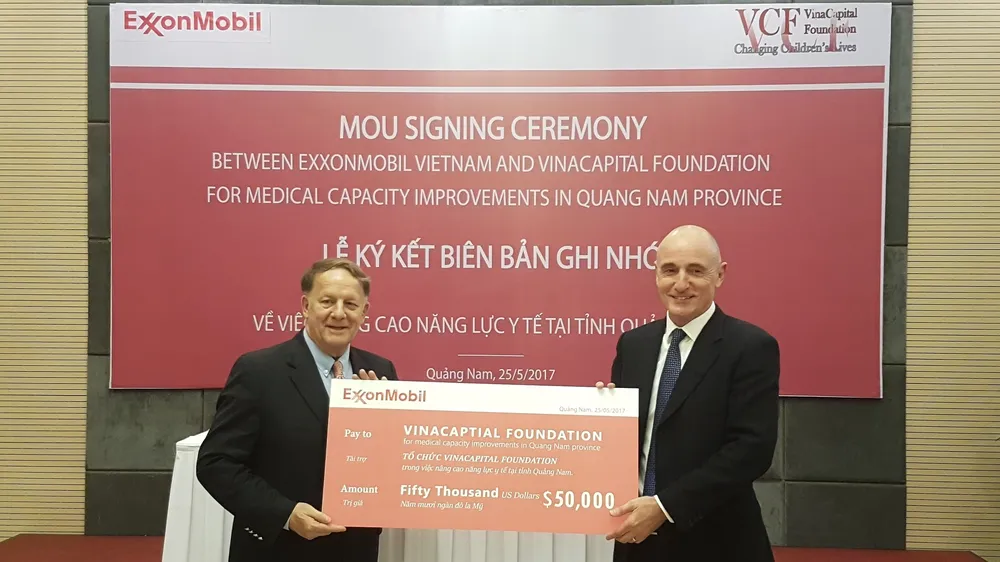 Đại diện lãnh đạo ExxonMobil trao bảng tài trợ cho đại diện Quỹ tài trợ VinaCapital. Ảnh: NGUYÊN KHÔI