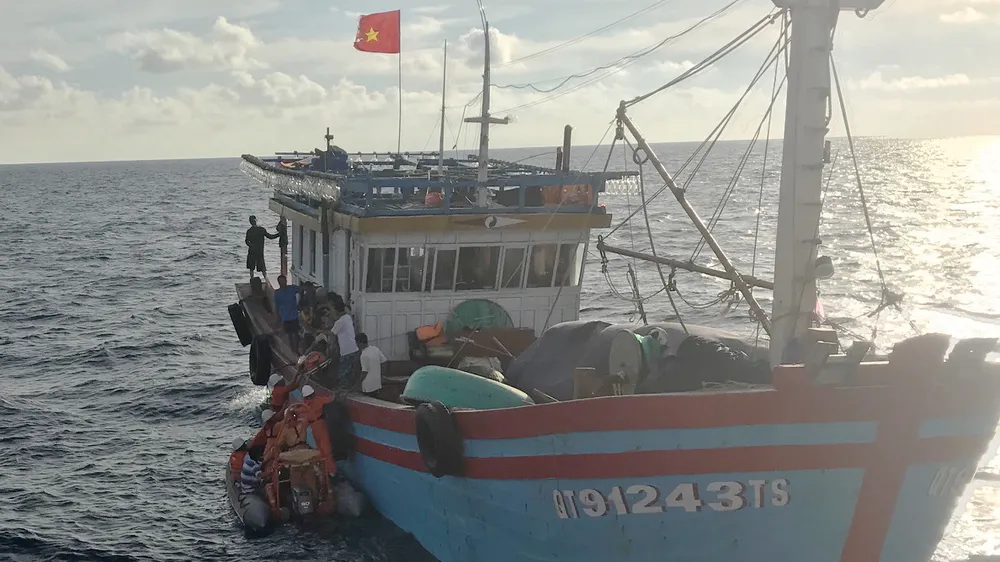 Các nhân viên tàu SAR 412 đưa xuồng cao su tiếp cận tàu cá và chuyển ngư dân Lê Thanh Hải sang tàu SAR 412 đưa về đất liền cấp cứu