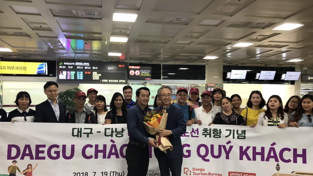 Ông Han Man Soo - Cục trưởng Cục du lịch - Văn hóa - Thể thao Deagu tặng hoa đón đoàn khách đầu tiên từ Đà Nẵng sang Deagu