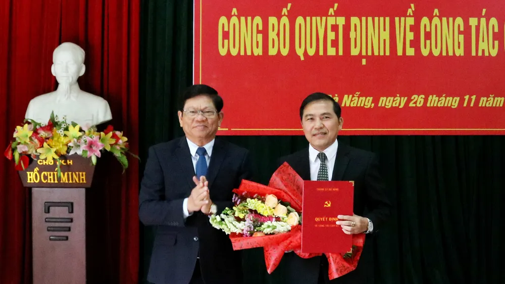 Ông Võ Công Trí, Phó Bí thư Thường trực Thành ủy Đà Nẵng trao quyết định và tặng hoa chúc mừng nhà báo Nguyễn Đức Nam