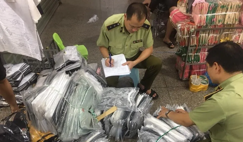 Cán bộ QLTT kiểm kê các lô hàng thời trang nhái, lậu trong chợ Ninh Hiệp hôm 4-6